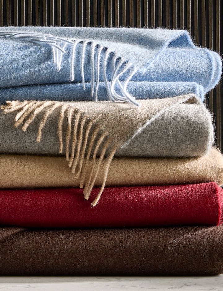 A stack of Paley throws in various colors.