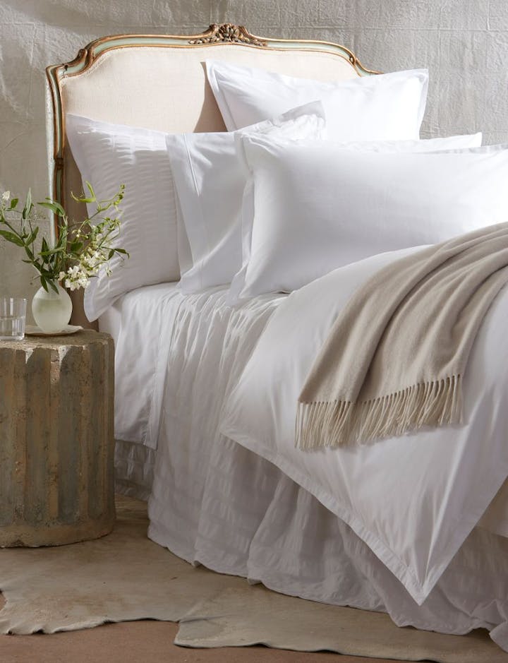 A view of a bed featuring Ceylon Satin Stitch.