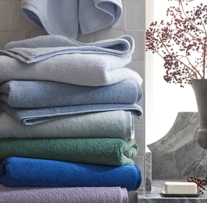 A stack of Milagro towels in an assortment of colors