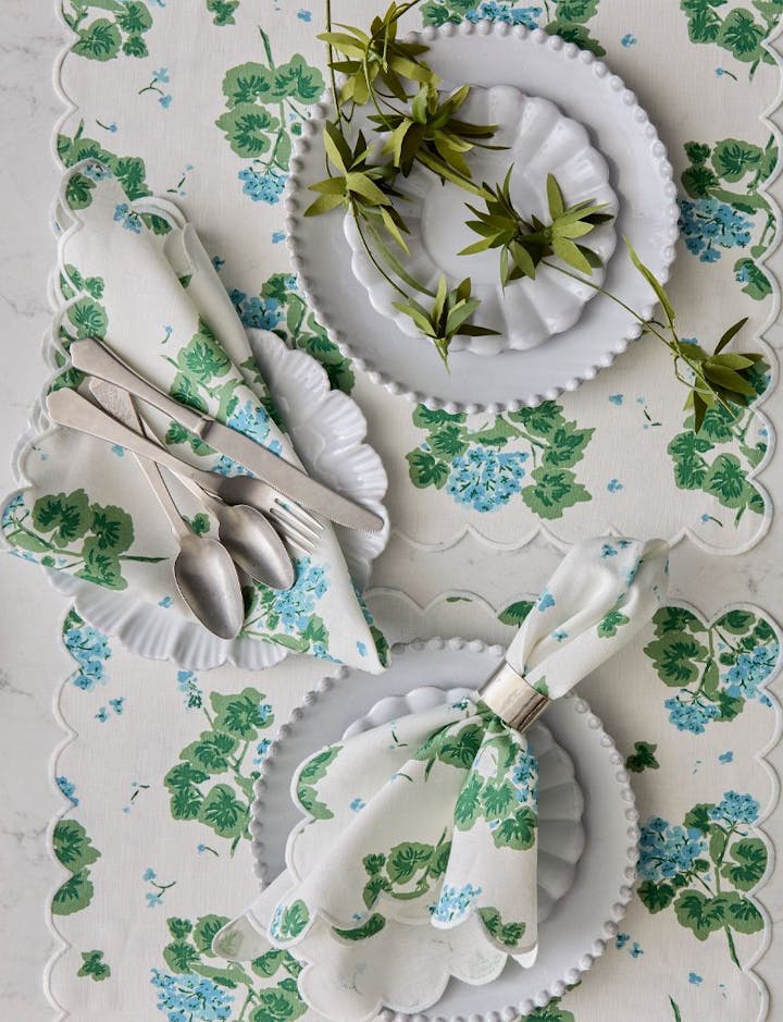 An overhead view of a table featuring Geranium linens