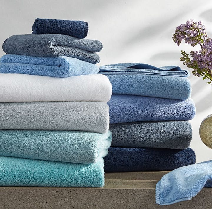 A stack of Milagro towels in an assortment of colors.