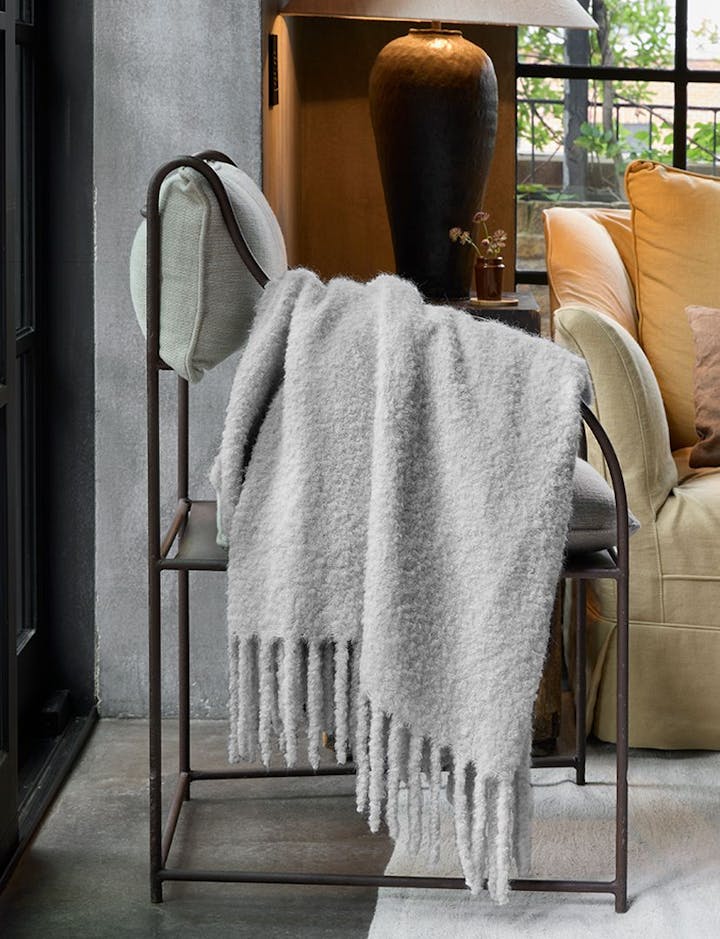 A view of a Poncho throw draped over a chair.