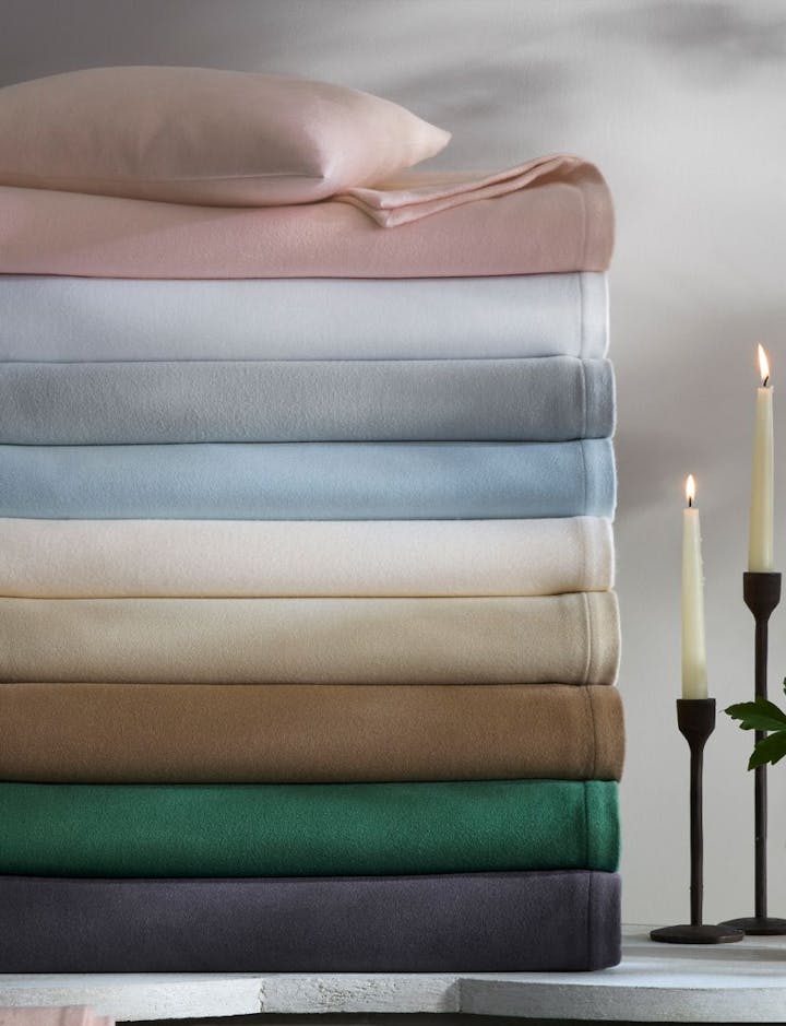A stack of Dream Modal blankets in various colors.