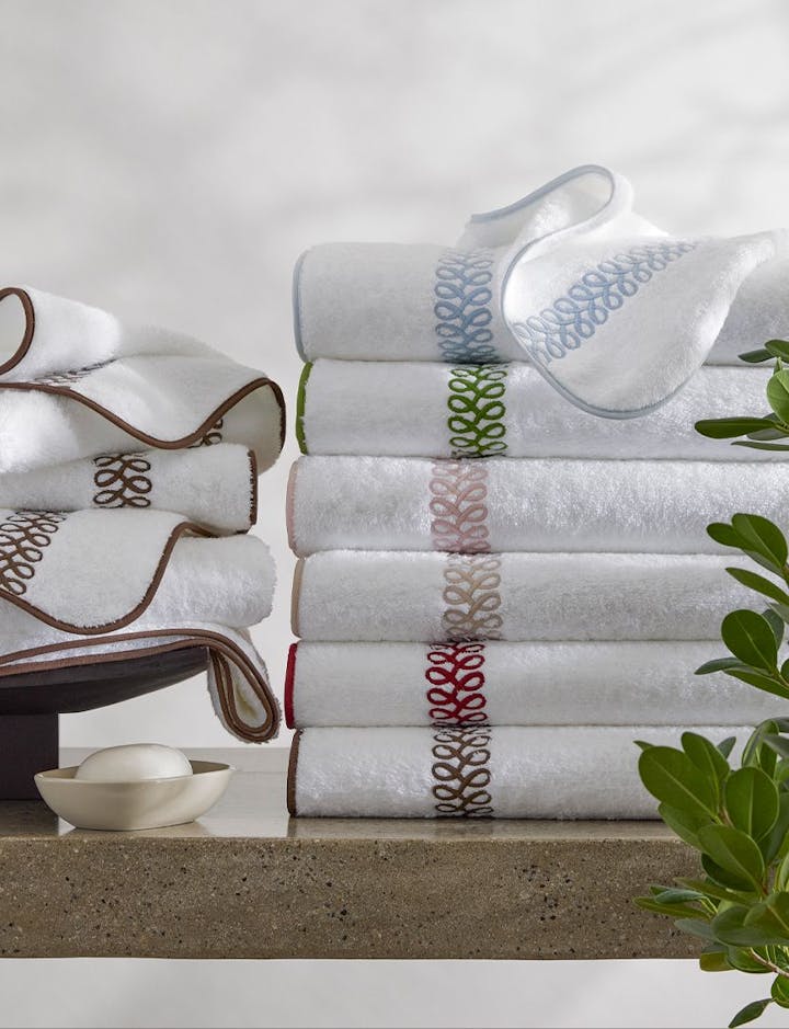A stack of Astor Braid towels in various colors.