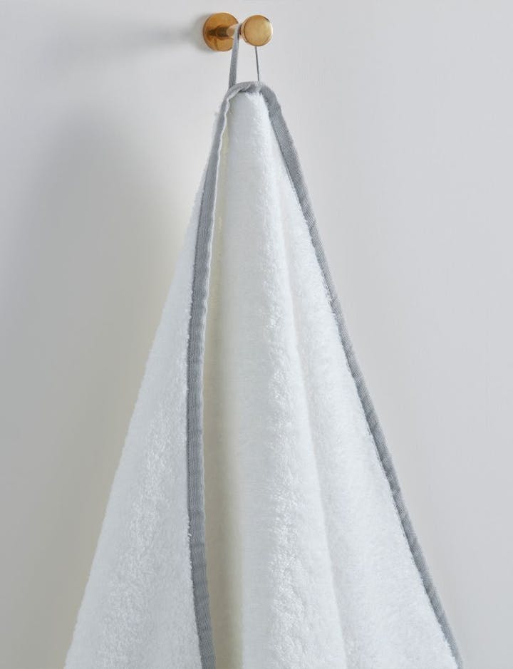 A view of an Enzo towel hanging from a hook