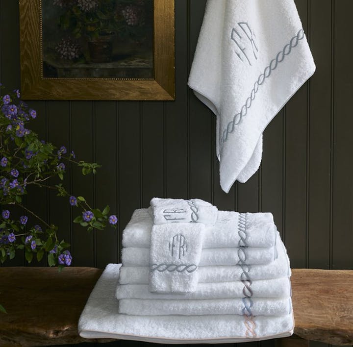 A stack of Classic Chain towels with one towel hanging above